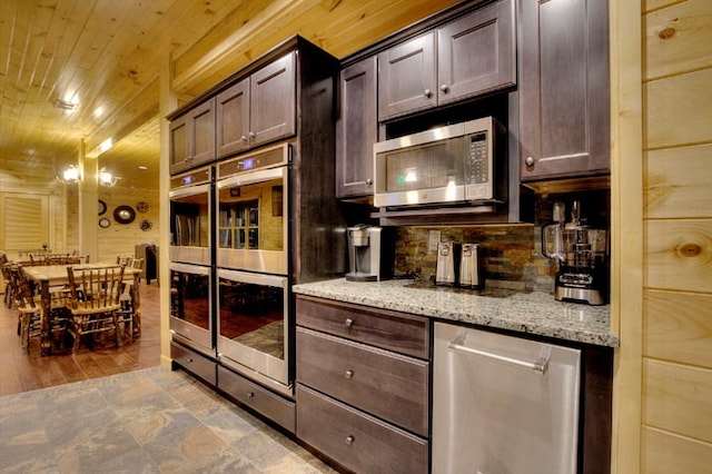 kitchen featuring light stone countertops, appliances with stainless steel finishes, dark brown cabinetry, and wooden ceiling