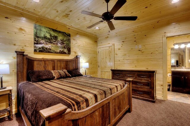 bedroom with wood walls, ensuite bathroom, ceiling fan, light colored carpet, and wood ceiling