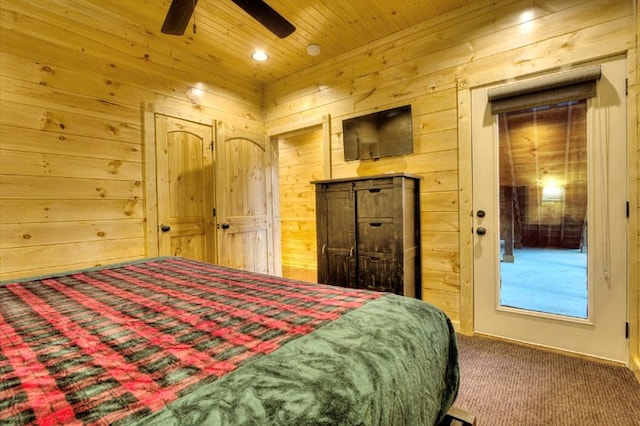 bedroom featuring ceiling fan, carpet floors, and wood walls