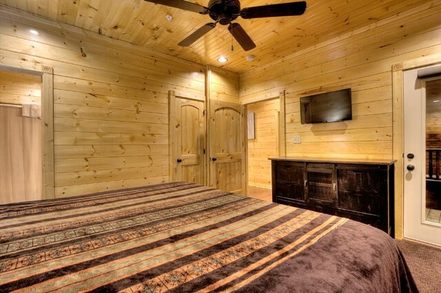 carpeted bedroom with ceiling fan, wood walls, and wooden ceiling