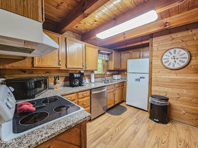kitchen with black microwave, stainless steel dishwasher, wood walls, freestanding refrigerator, and under cabinet range hood