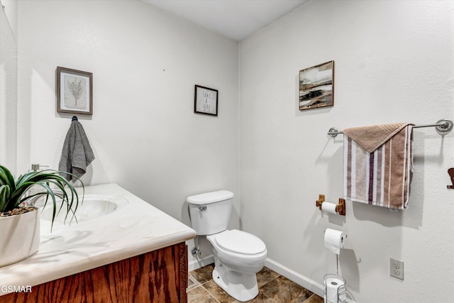 bathroom with toilet, baseboards, tile patterned floors, and vanity