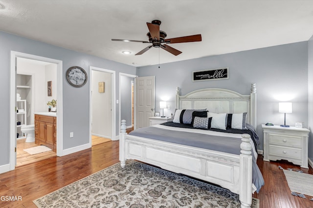 bedroom featuring baseboards, connected bathroom, and wood finished floors