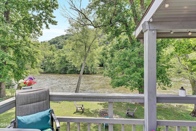 view of yard with a water view, a dock, and a wooded view