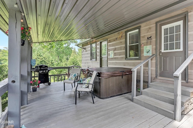 wooden terrace featuring entry steps, a hot tub, and a grill