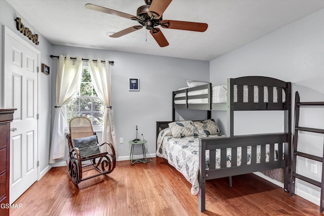 bedroom with baseboards, a ceiling fan, and wood finished floors