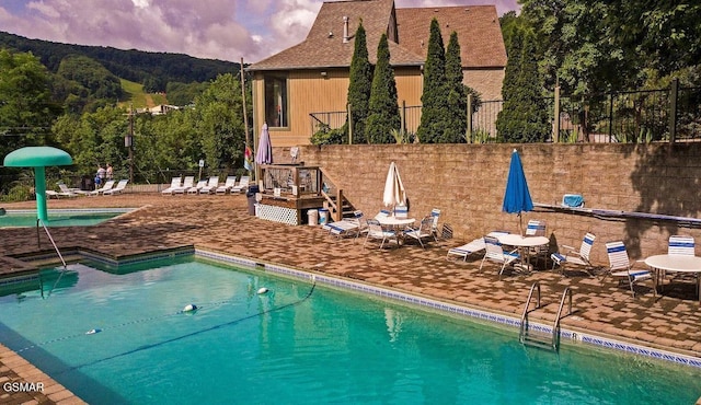 pool at dusk featuring a patio