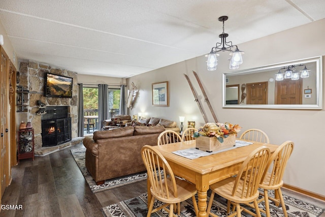 dining area featuring a fireplace, dark wood-type flooring, and a textured ceiling