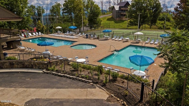 view of swimming pool featuring a hot tub and a patio area