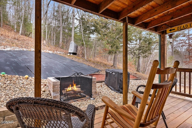 deck with an outdoor stone fireplace