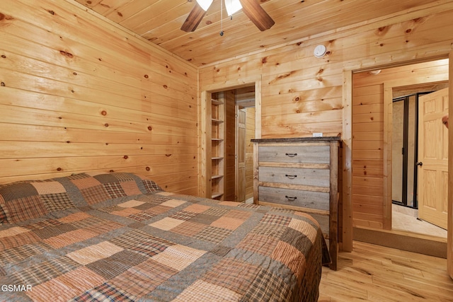 bedroom with ceiling fan, light wood-type flooring, wooden ceiling, and wooden walls