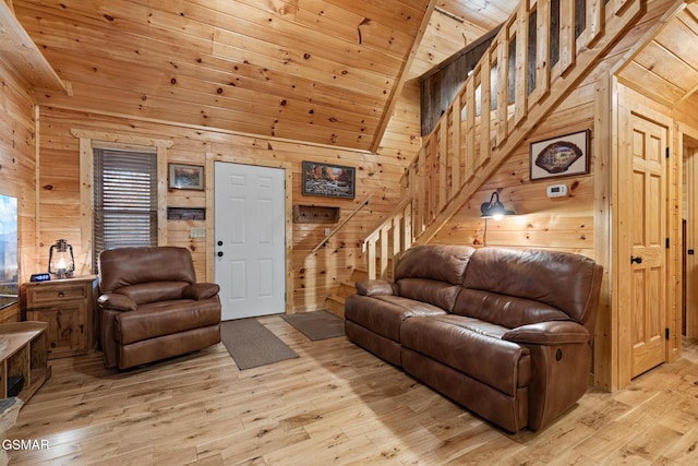 living room with wooden walls, wood ceiling, lofted ceiling, and light hardwood / wood-style floors