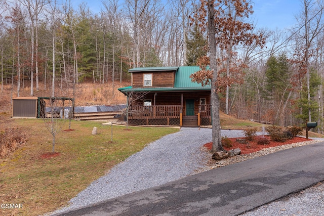 cabin with covered porch and a front lawn