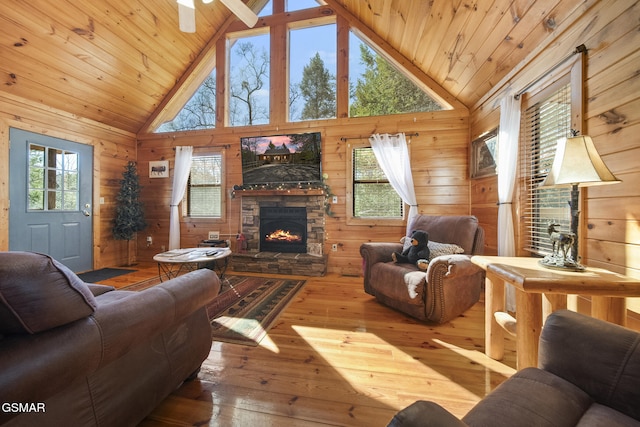 living room with wooden ceiling, wood walls, hardwood / wood-style flooring, and a stone fireplace