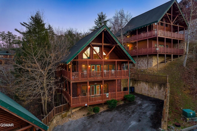 back house at dusk with a balcony