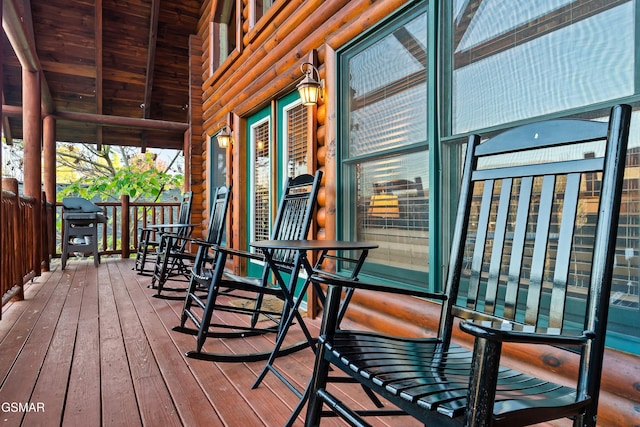 wooden terrace with a grill and covered porch