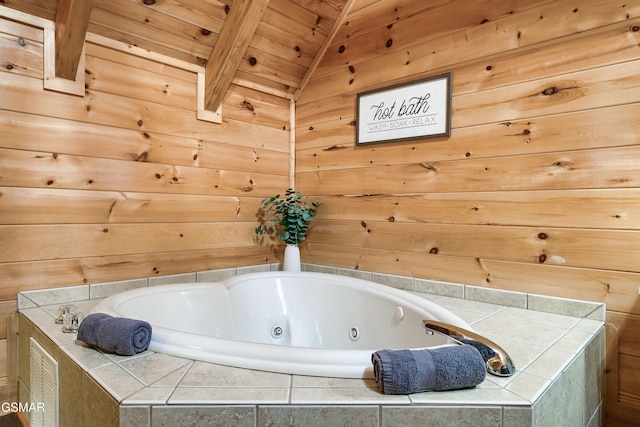 bathroom featuring a relaxing tiled tub, wood ceiling, wooden walls, and lofted ceiling with beams