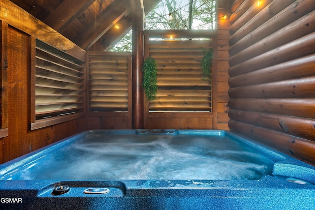 exterior space featuring vaulted ceiling with beams, log walls, a jacuzzi, and wooden ceiling