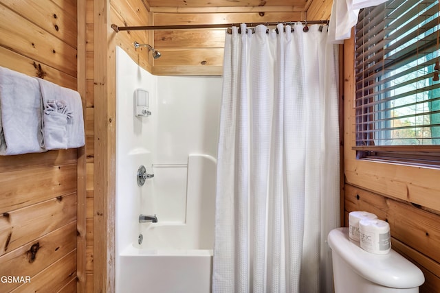 bathroom featuring shower / bathtub combination with curtain, toilet, and wood walls