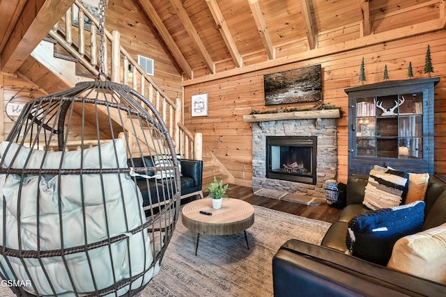 living room with a stone fireplace, wooden ceiling, wooden walls, beamed ceiling, and hardwood / wood-style floors