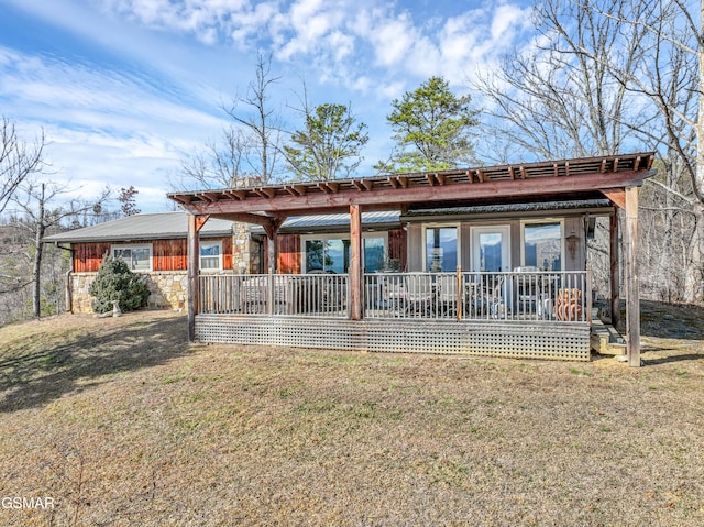 back of property with covered porch and a lawn