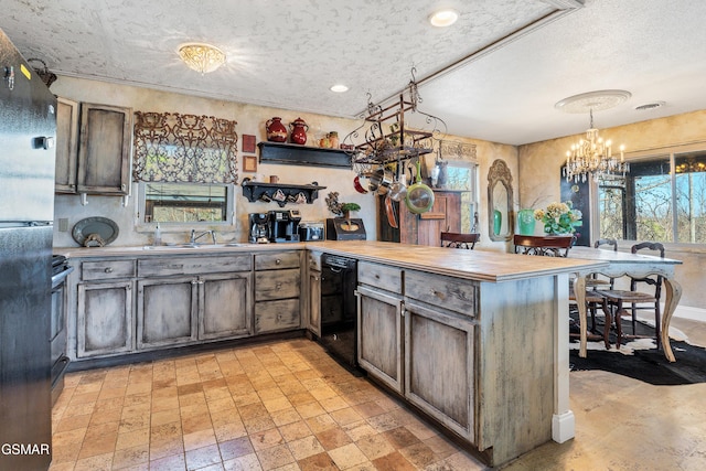 kitchen with sink, an inviting chandelier, black appliances, decorative light fixtures, and kitchen peninsula