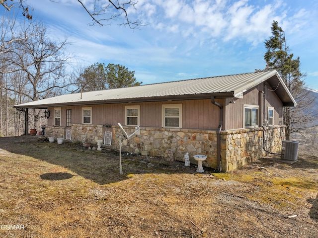 rear view of house featuring central AC and a lawn