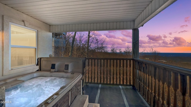 deck at dusk with a hot tub