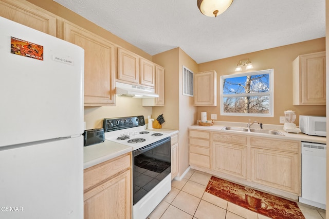 kitchen featuring white appliances, light brown cabinetry, sink, and light tile patterned floors