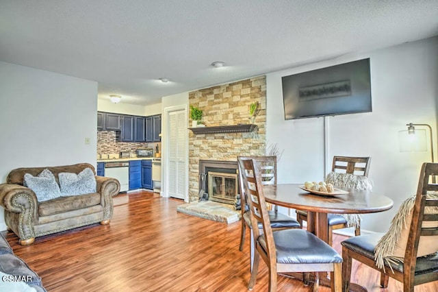 dining room featuring a fireplace and light wood-style flooring