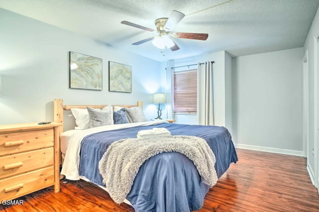 bedroom with a ceiling fan, baseboards, dark wood finished floors, and a textured ceiling