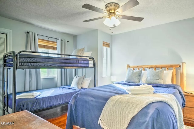 bedroom featuring ceiling fan, a textured ceiling, and wood finished floors