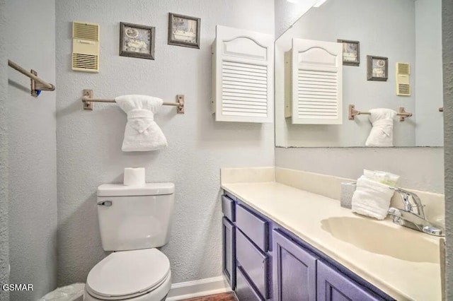 bathroom featuring toilet, baseboards, and vanity