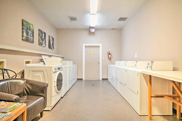 community laundry room with light floors, independent washer and dryer, and visible vents