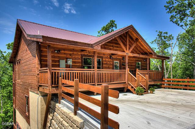 log-style house with a wooden deck