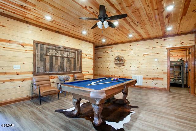 rec room with hardwood / wood-style floors, ceiling fan, wood walls, and pool table