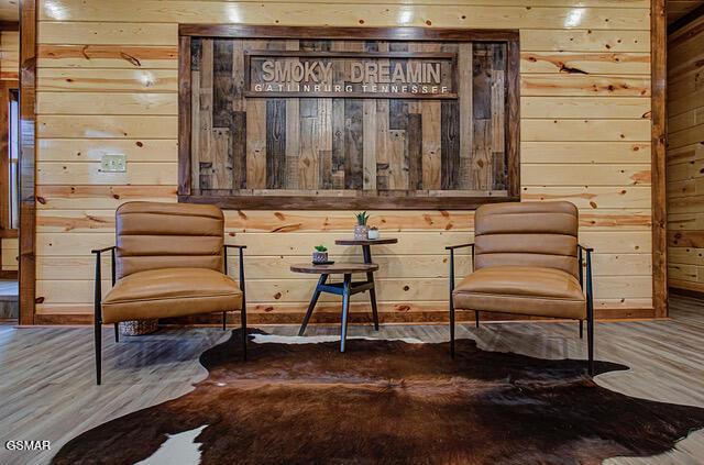 living area with wood walls and hardwood / wood-style flooring