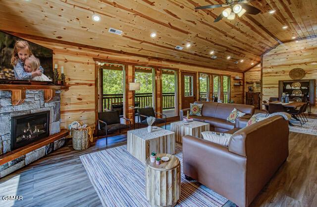 living room featuring a fireplace, ceiling fan, dark wood-type flooring, and wood ceiling