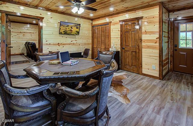 dining room with hardwood / wood-style flooring, ceiling fan, wooden walls, and wood ceiling