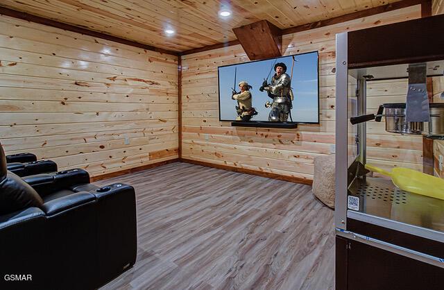 home theater room featuring hardwood / wood-style floors, wooden walls, and wood ceiling