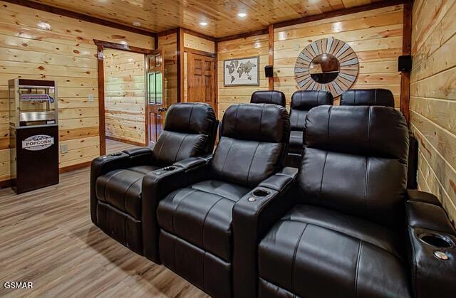 home theater room featuring light wood-type flooring, wooden ceiling, and wood walls