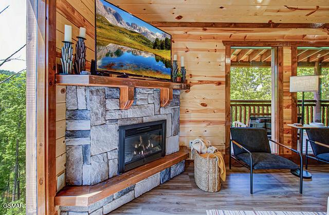 sitting room featuring wooden ceiling, a fireplace, hardwood / wood-style floors, and wood walls