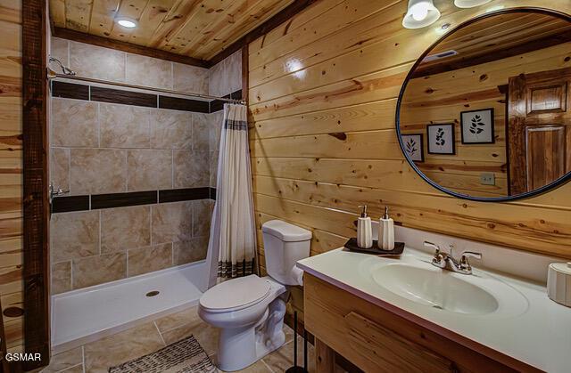 bathroom with vanity, a shower with curtain, wooden walls, toilet, and wood ceiling