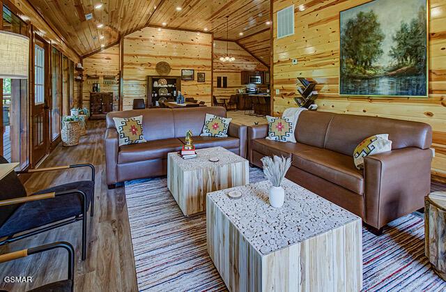 living room featuring hardwood / wood-style floors, lofted ceiling, wood walls, and wooden ceiling