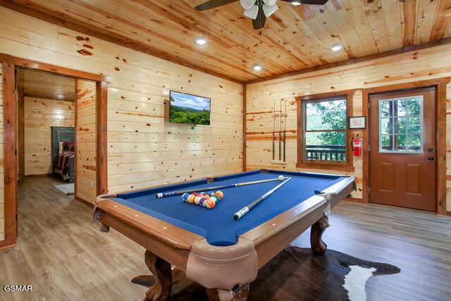 recreation room featuring hardwood / wood-style floors, wooden walls, wooden ceiling, and billiards