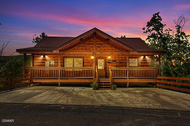 log-style house with covered porch