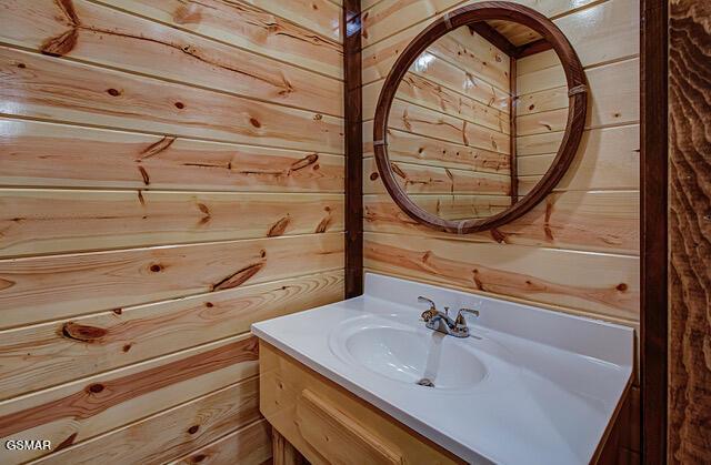 bathroom featuring vanity and wooden walls