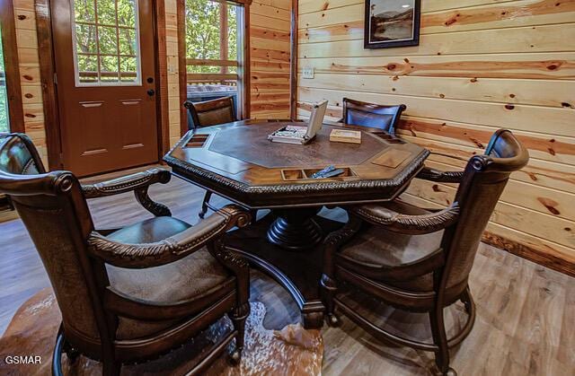 interior space with hardwood / wood-style flooring and wood walls