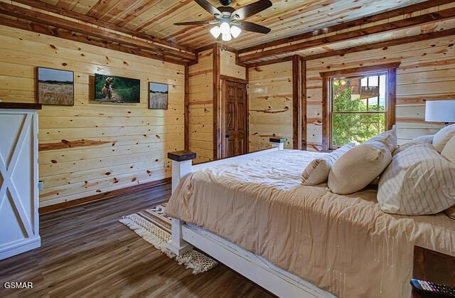 bedroom with ceiling fan, wood walls, wood ceiling, and dark wood-type flooring