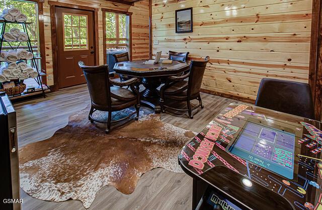 dining area featuring hardwood / wood-style floors and wood walls